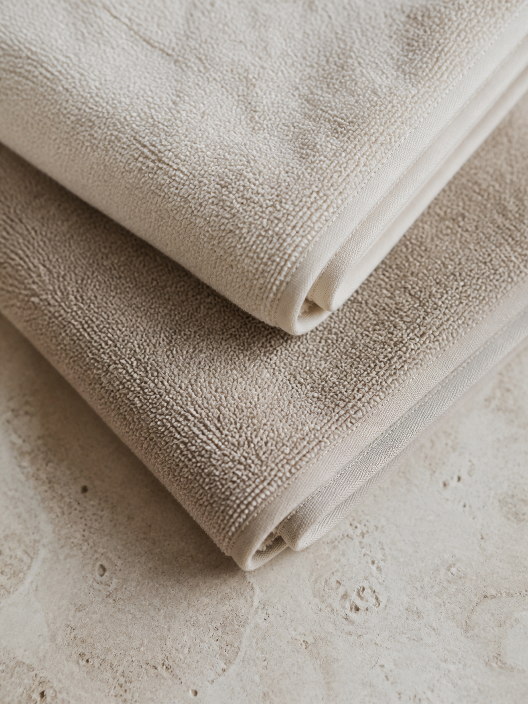 Close view of folded ivory and taupe terry towels