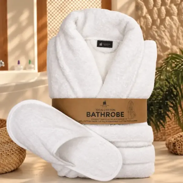 Folded white cotton terry bathrobe with matching slippers