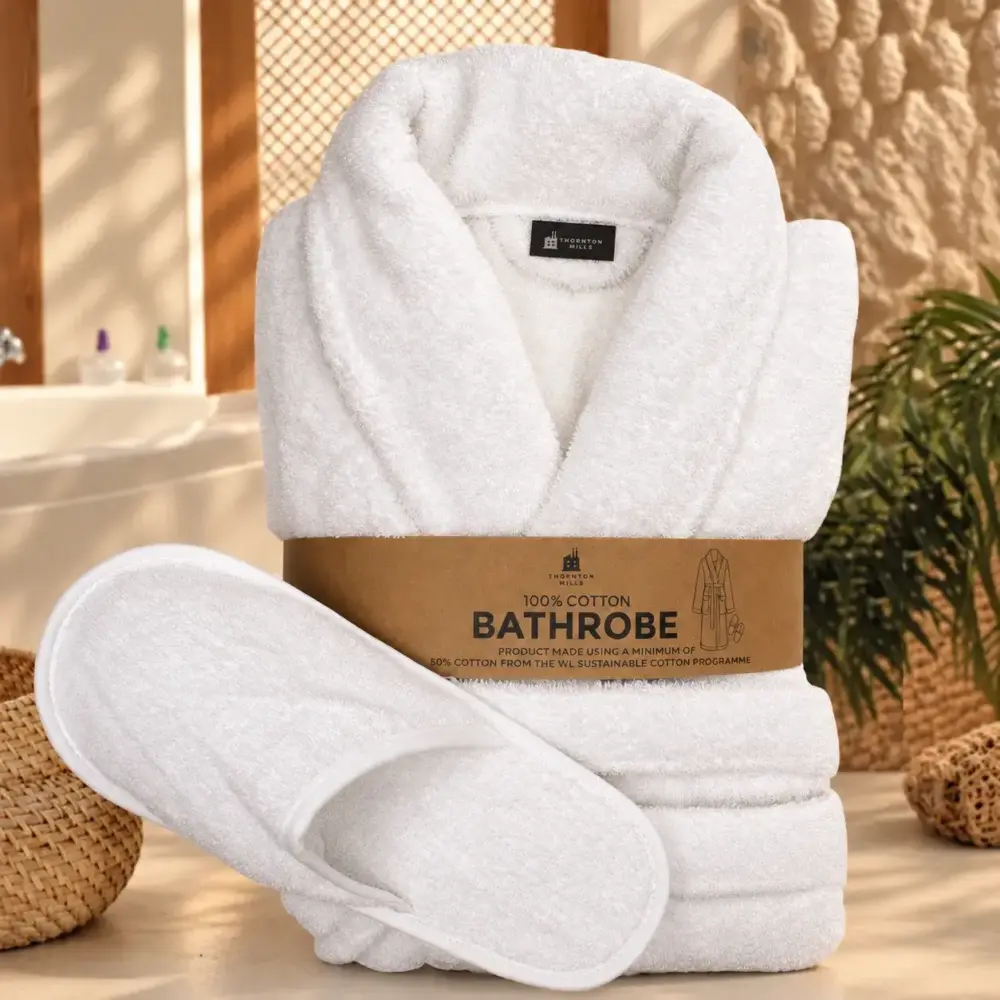 Folded white cotton terry bathrobe with matching slippers